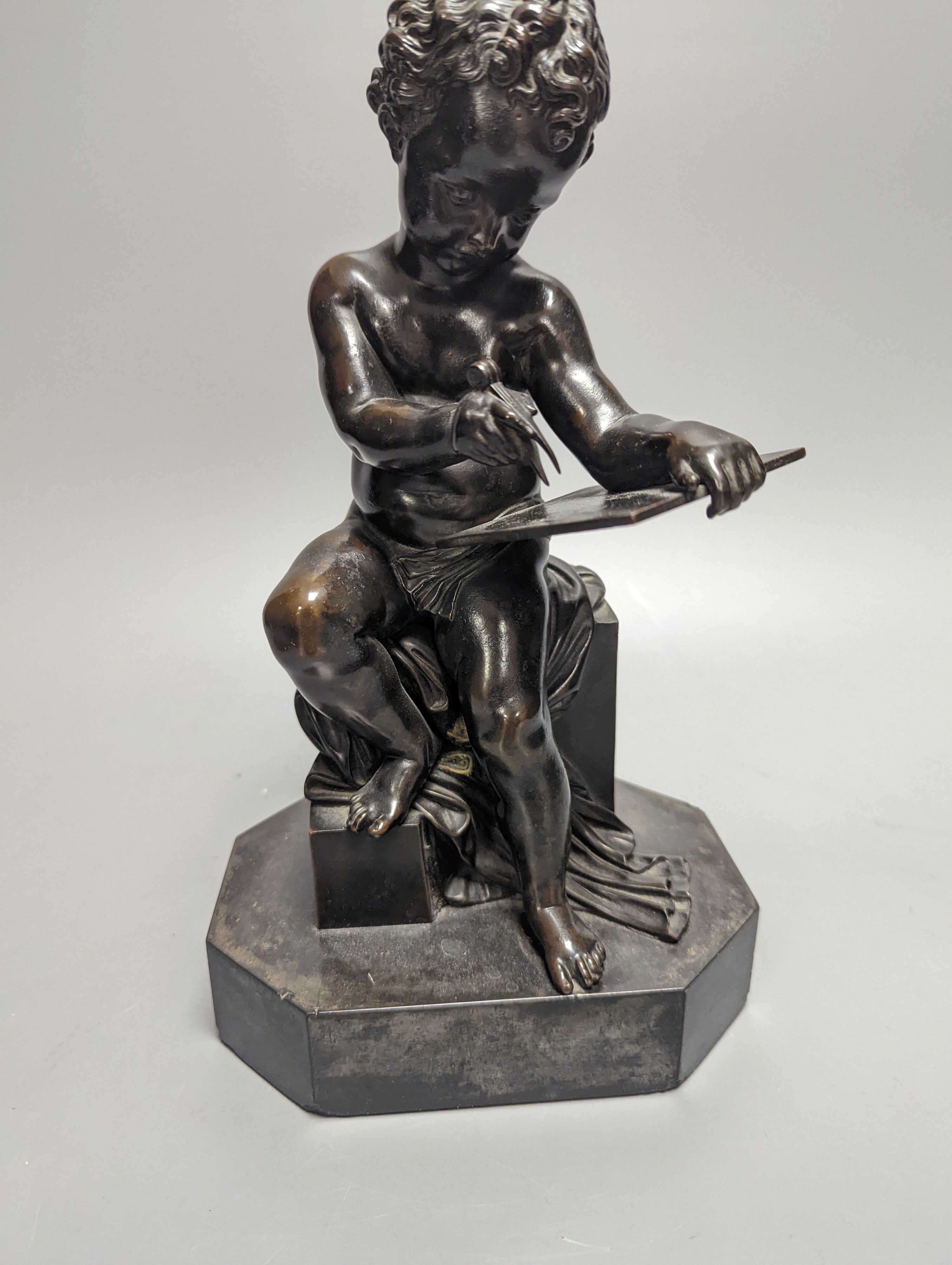 A pair of late 19th century bronze figures of seated putti plotting and writing notes, 26cm